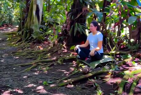 Illustrative screenshot from @eltravelitoshow Instagram reel featuring a woman experiencing forest therapy at Mistico Park