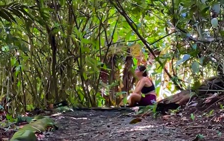 Illustrative screenshot from @eltravelitoshow Instagram feed featuring a woman exploring Mistico Park during her forest therapy session